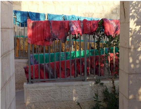 Child proudly wearing tie-dye tzitzit